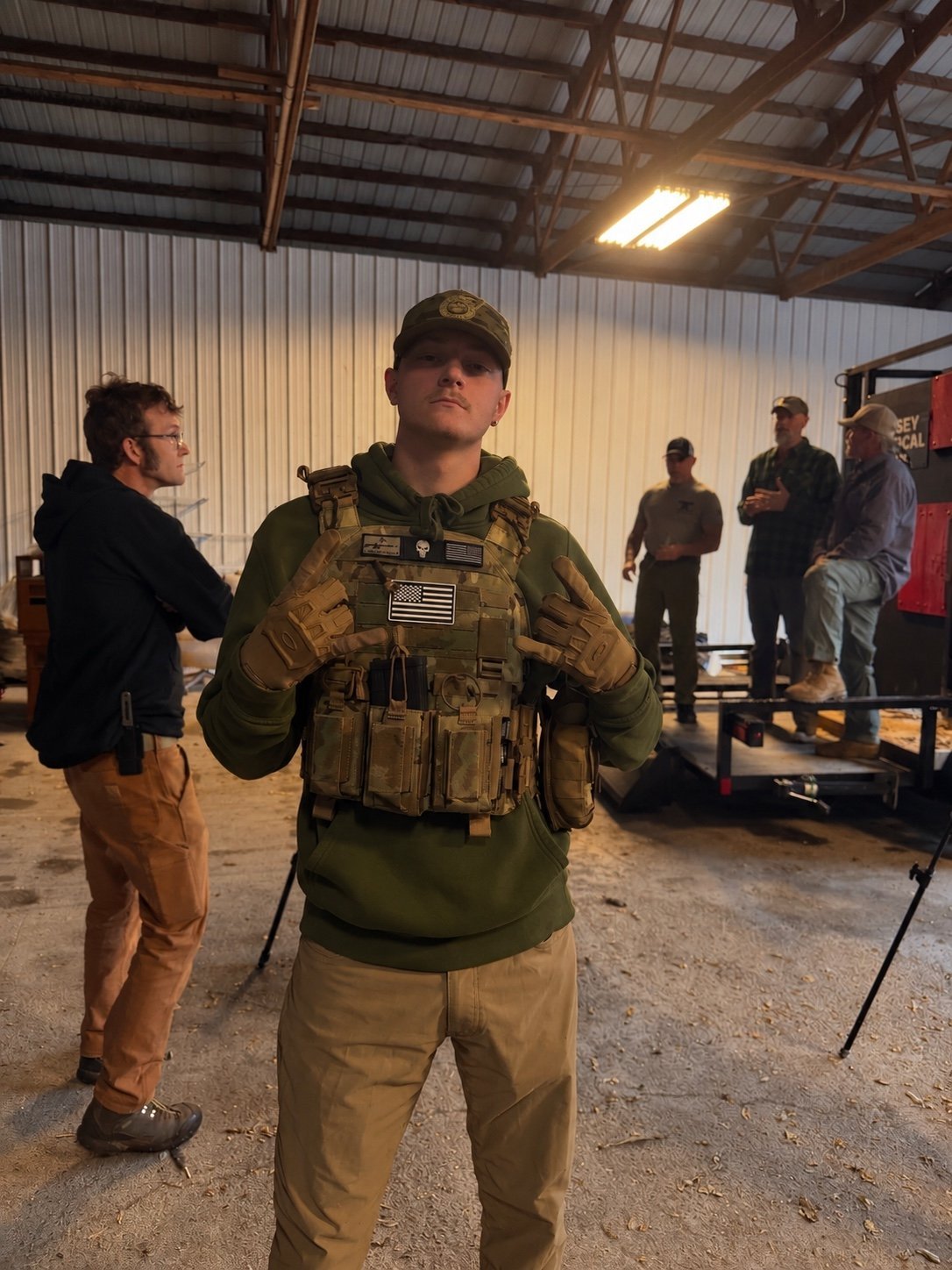 Ashton Dusek, Founder & CEO of Summit Advisory Group, in tactical gear during a defense-industry demonstration in an industrial warehouse